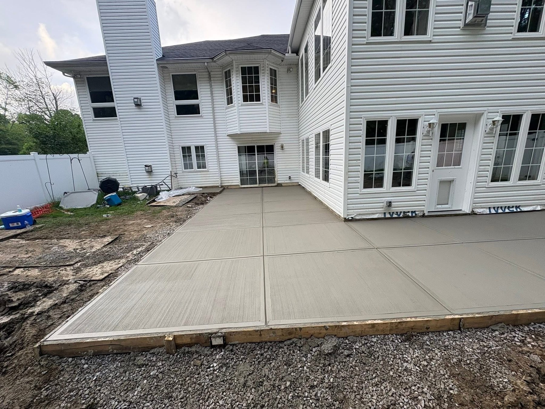 Fresh concrete patio installation beside a home
